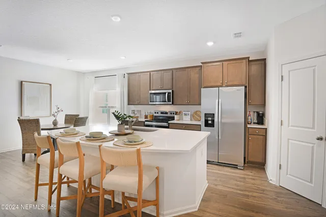 a kitchen with refrigerator cabinets dining table and chairs
