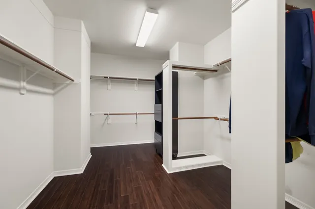 a view of walk in closet with wooden floor