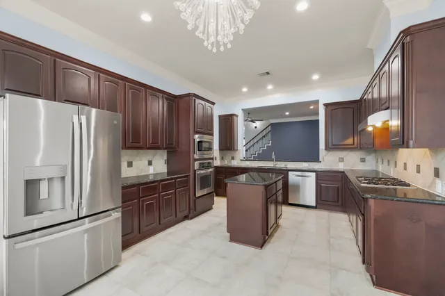 a kitchen with stainless steel appliances granite countertop a sink stove and refrigerator