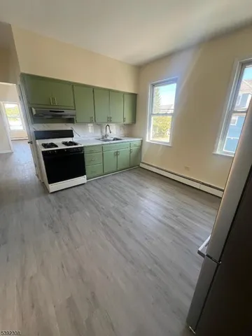 a view of kitchen with sink and refrigerator