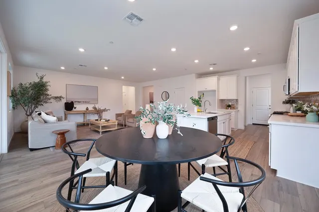 a kitchen with stainless steel appliances granite countertop a sink a stove and a white cabinets