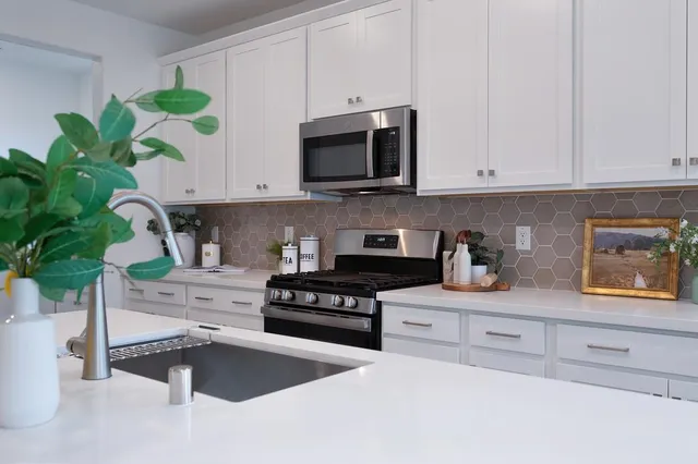 a kitchen with stainless steel appliances granite countertop a table chairs sink refrigerator and cabinets