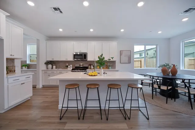 a kitchen with a table chairs stove and microwave