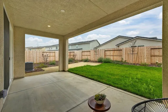 a backyard of a house with table and chairs