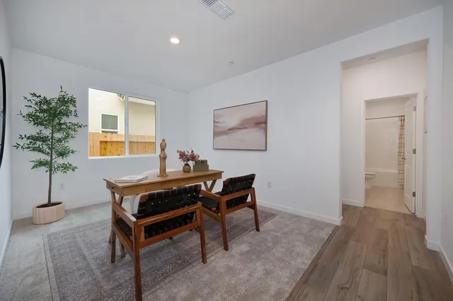 a view of a workspace room with furniture and a window