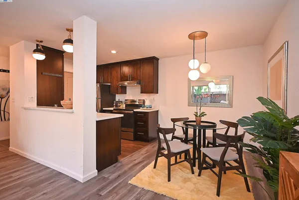 a kitchen with furniture wooden floor dining table and stainless steel appliances
