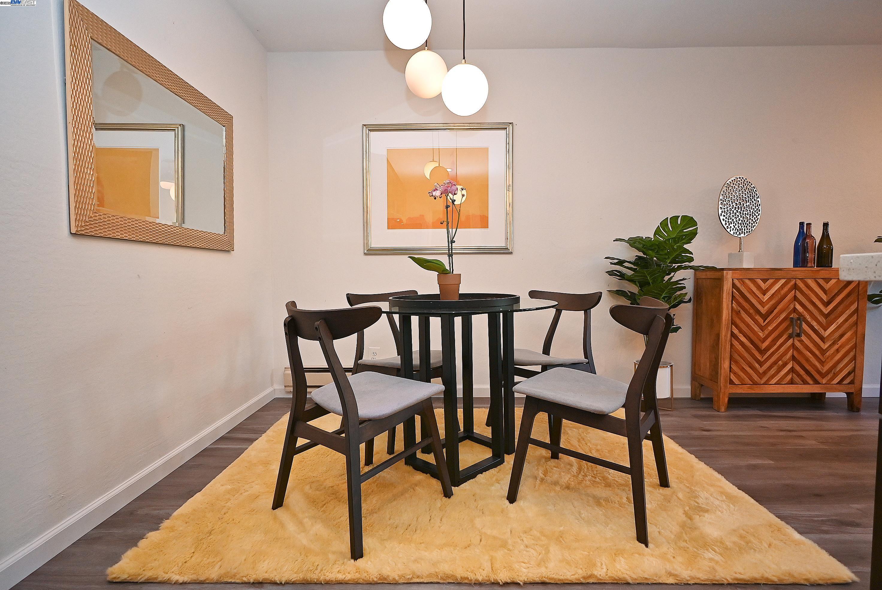 1333 Webster Street, Unit A107 Alameda, CA 94501 - Photo 12 of 27 a view of a dining room with furniture wooden floor and a chandelier
