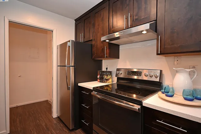 a kitchen with a refrigerator and a stove top oven