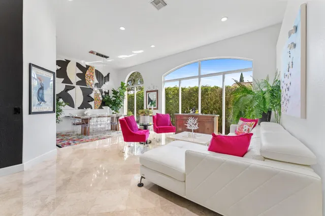 a living room with furniture and floor to ceiling window