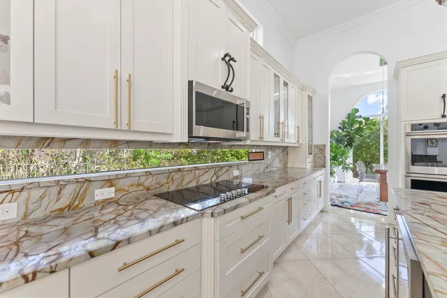 a kitchen with granite countertop a sink and a stove top oven