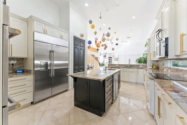 a kitchen with stainless steel appliances granite countertop a refrigerator and a sink