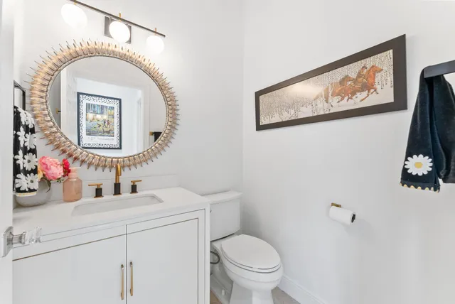 a bathroom with a sink mirror and toilet