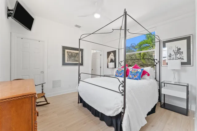 a bedroom with a bed and a flat tv screen on the wall