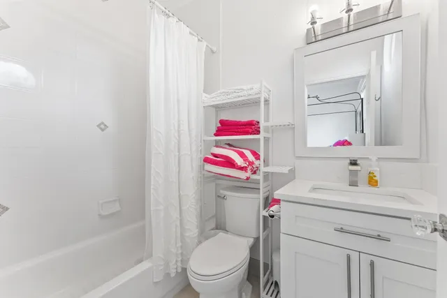 a bathroom with a sink toilet vanity and tub