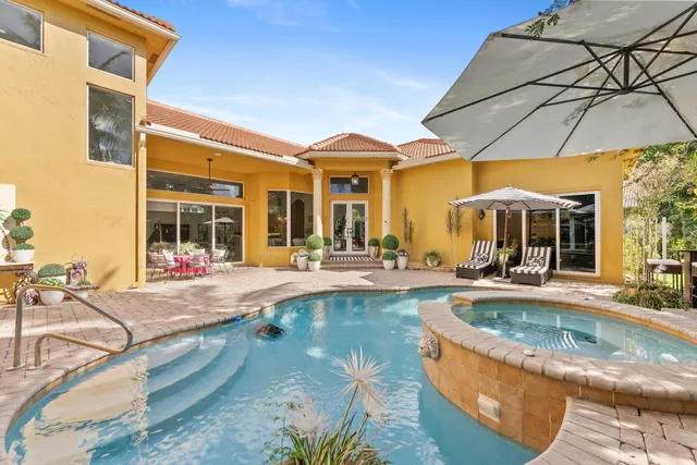 a view of a house with swimming pool and sitting area
