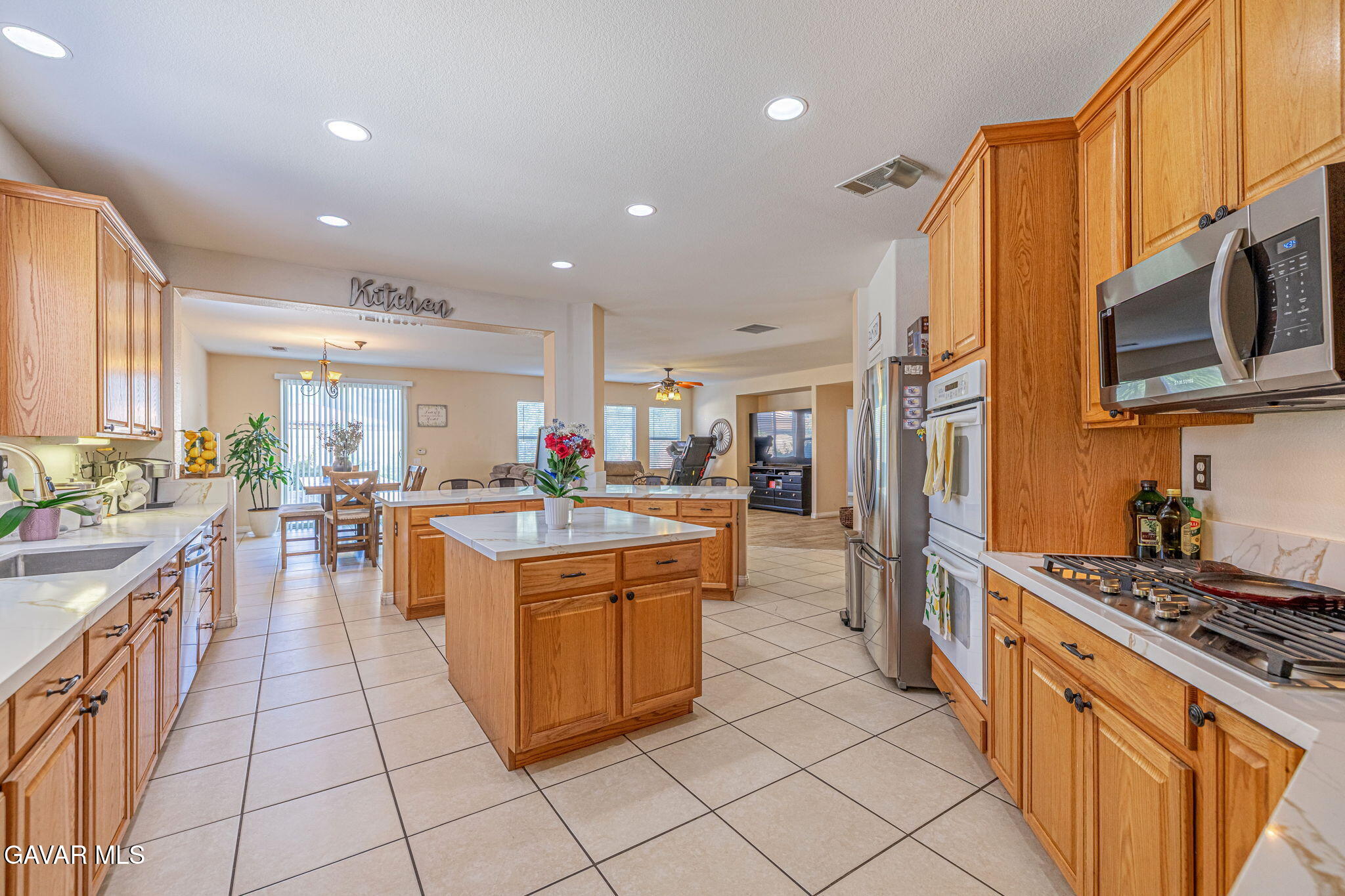 4302 Olivera Place Lancaster, CA 93536 - Photo 21 of 62 a kitchen with stainless steel appliances granite countertop a stove top oven a sink dishwasher and cabinets