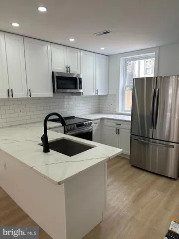 a kitchen with stainless steel appliances a refrigerator stove microwave and cabinets