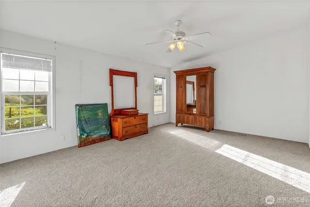 an empty room with windows and cabinet