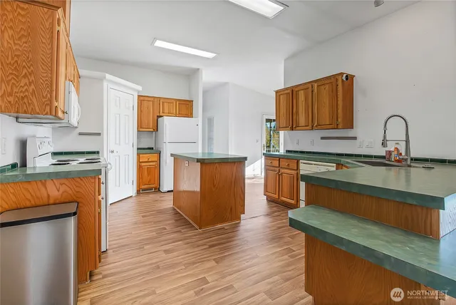 a kitchen with stainless steel appliances granite countertop a sink and a refrigerator