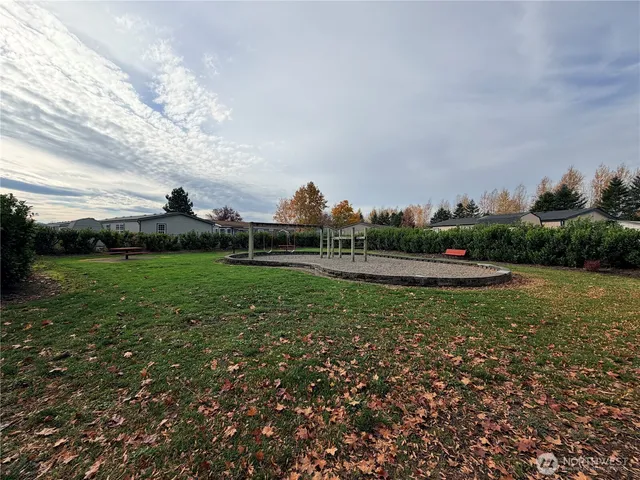 a view of green field with house in background