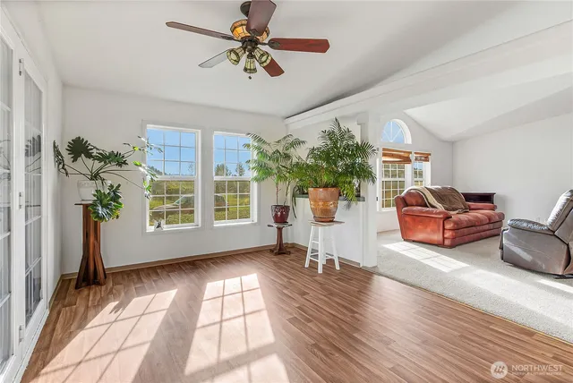 a living room with furniture and a large window with wooden floor