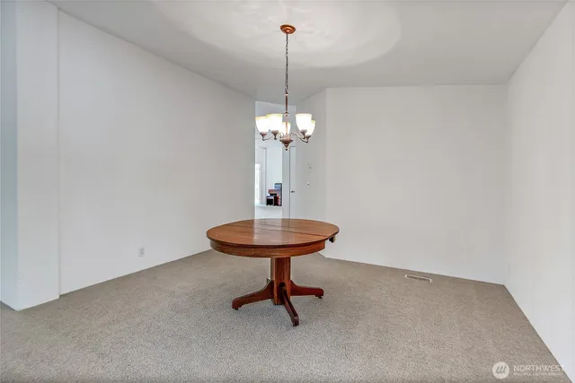 a view of a room with a chandelier and table
