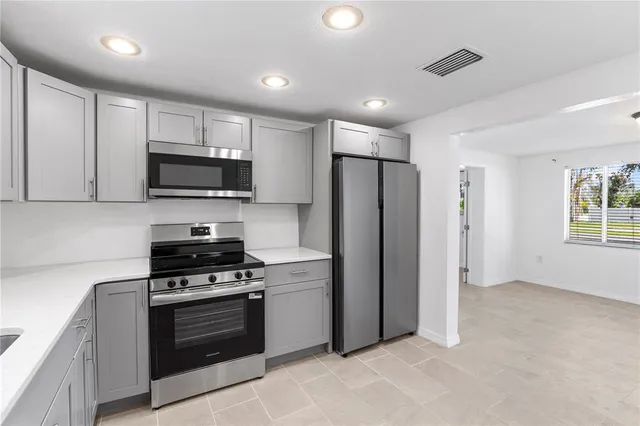 a kitchen with stainless steel appliances a refrigerator stove and microwave