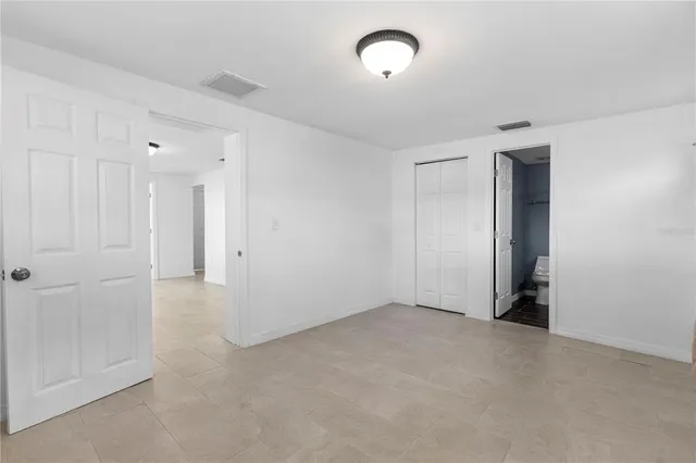 an empty room with an entryway and closet