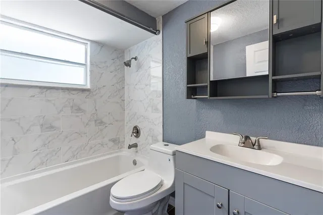 a bathroom with a sink toilet vanity and bathtub