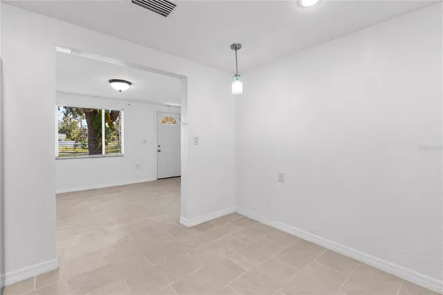 en empty room with windows and ceiling fan