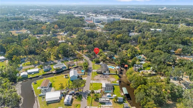 an aerial view of residential houses with outdoor space and trees
