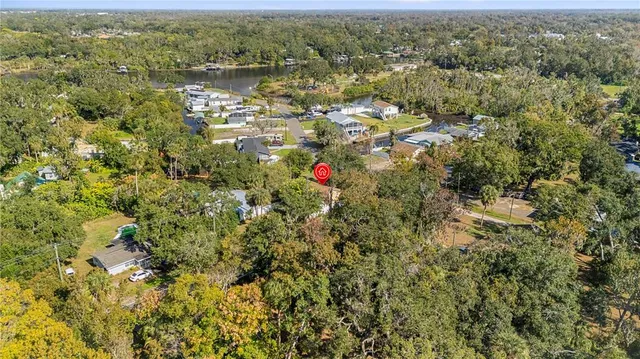 an aerial view of residential houses with outdoor space and trees