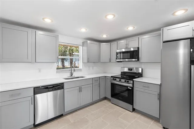 a kitchen with a sink stainless steel appliances and cabinets