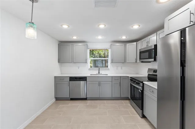 a kitchen with stainless steel appliances granite countertop a sink and stove top oven