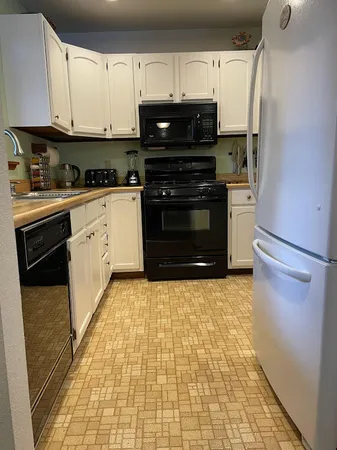a kitchen with stainless steel appliances a stove a refrigerator and cabinets