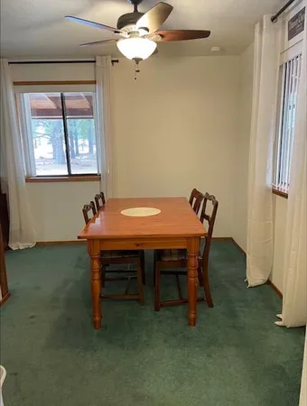 a view of a room with a table chairs and windows