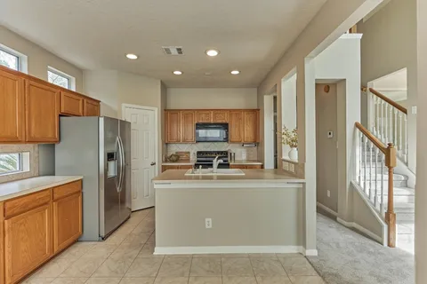 a kitchen that has a sink a stove and a refrigerator