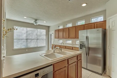 a kitchen with granite countertop a refrigerator and wooden cabinets