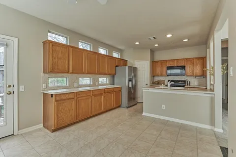 wooden floor in an empty room with a chandelier fan