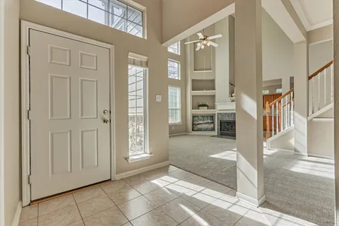 a living room with furniture a fireplace and a large window