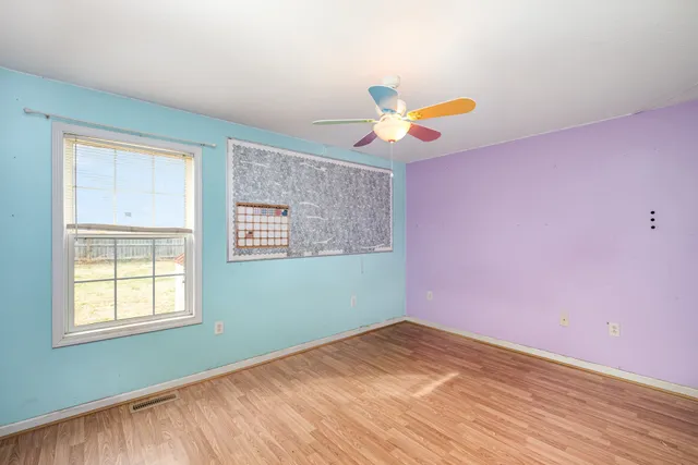 wooden floor in an empty room with a window