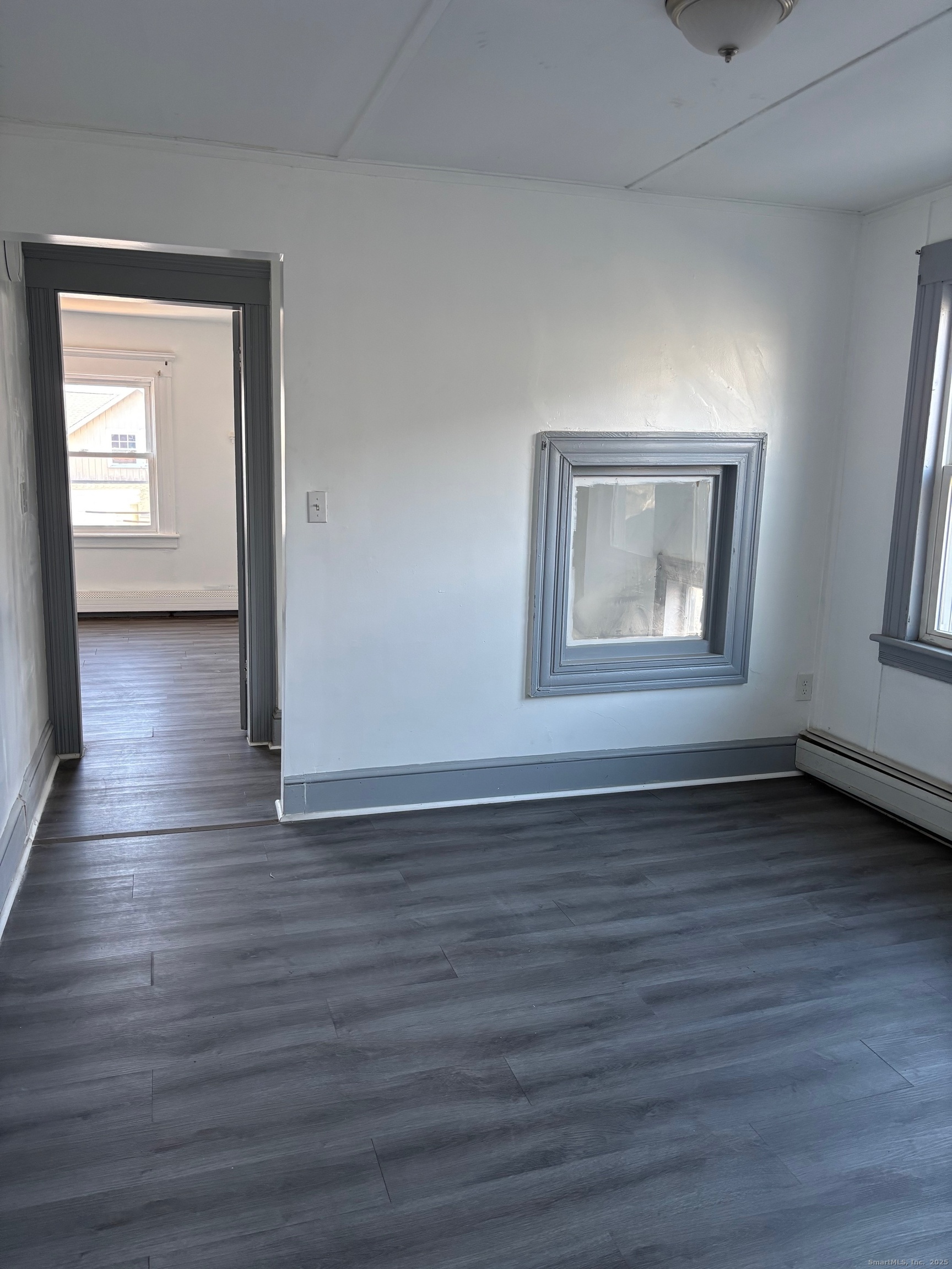 464 Wilmot Avenue Bridgeport, CT 06607 - Photo 16 of 19 a view of an empty room with wooden floor and a window