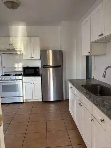 a kitchen with stainless steel appliances granite countertop a refrigerator sink and cabinets