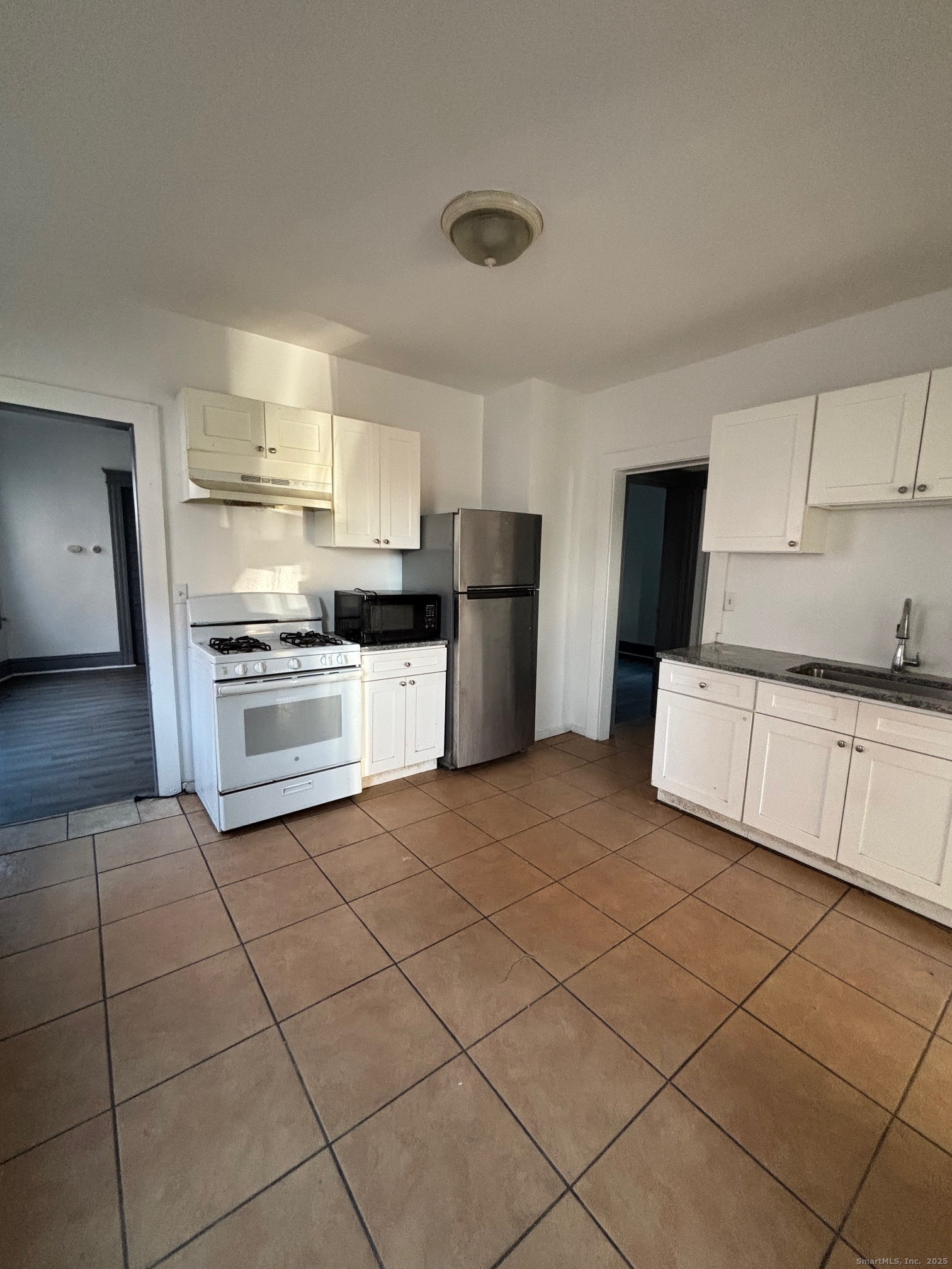464 Wilmot Avenue Bridgeport, CT 06607 - Photo 7 of 19 a kitchen with a sink a stove top oven and cabinets