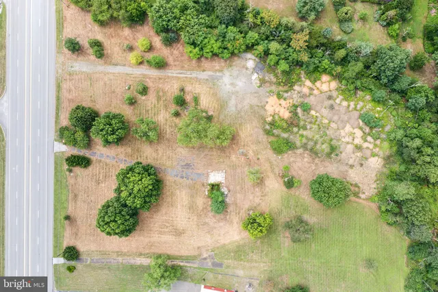 an aerial view of a residential house with yard and green space