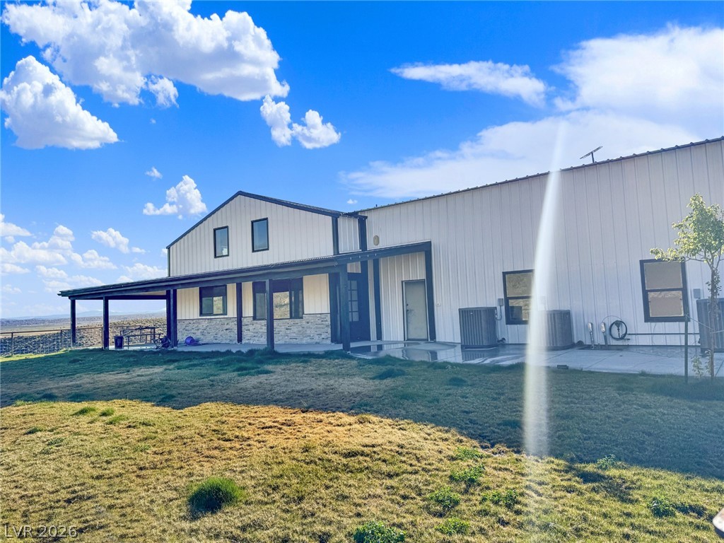 9393 North 93rd Highway Caliente, NV 89008 - Photo 30 of 41 A modern rural retreat boasts expansive outdoor space, blending sleek siding with natural stone accents.