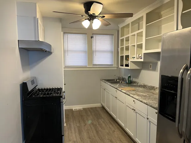 a kitchen with stainless steel appliances granite countertop a sink a stove and a refrigerator