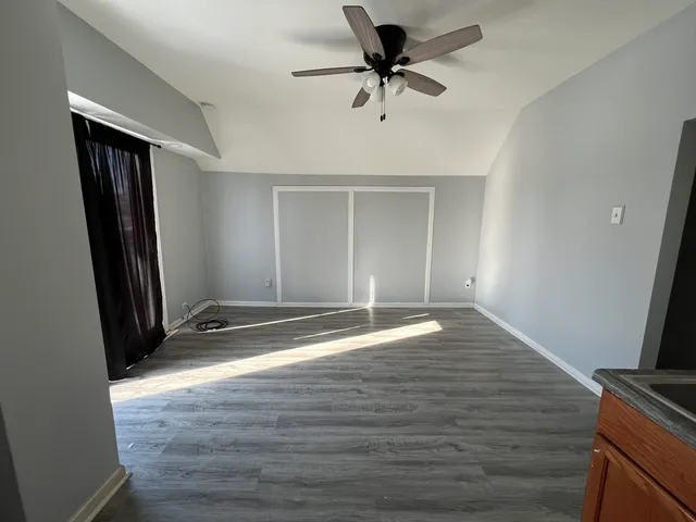 a view of empty room with wooden floor