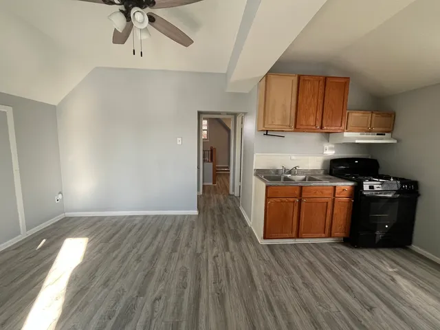 a kitchen with stainless steel appliances granite countertop a refrigerator a stove and a wooden floors