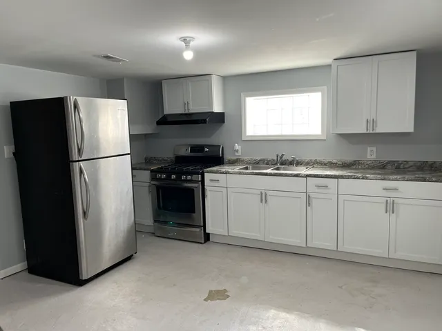a kitchen with a refrigerator sink stove and cabinets